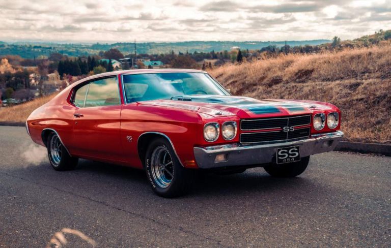 Red classic muscle car on a hillside road