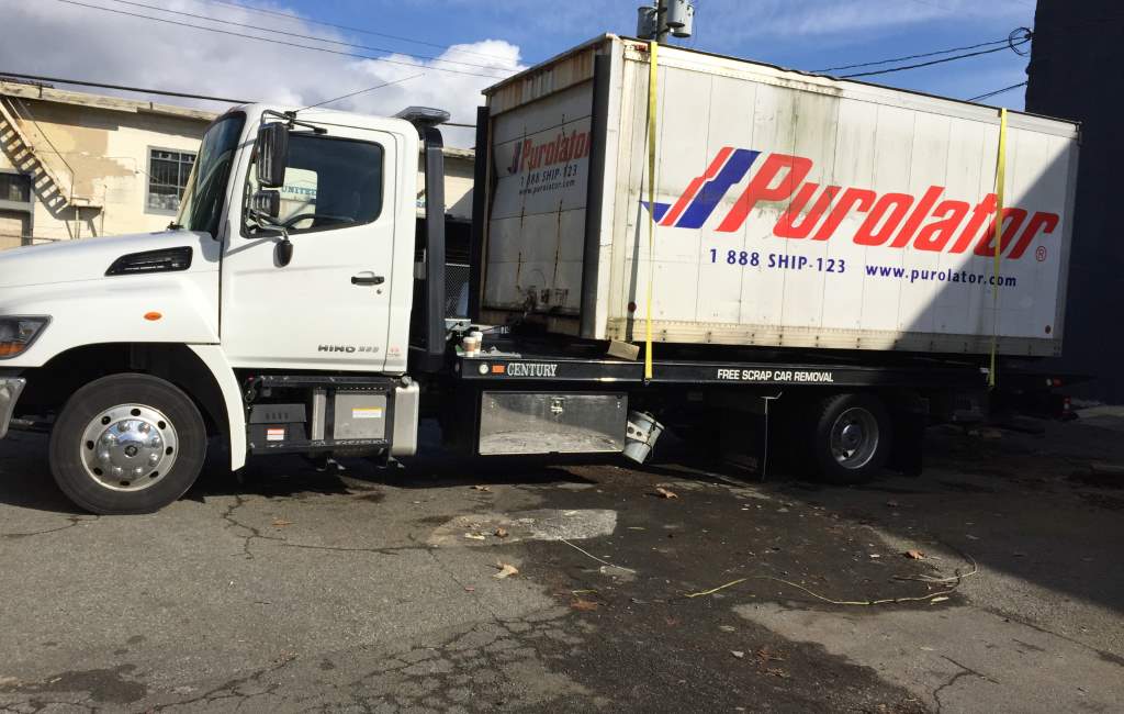 Hino flatbed transporting a commercial vehicle body