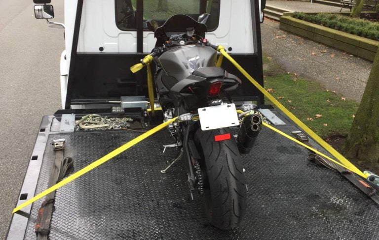 Motorcycle strapped down on a flatbed tow truck