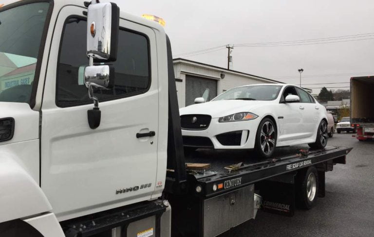 Sedan loaded on a Hino flatbed tow truck
