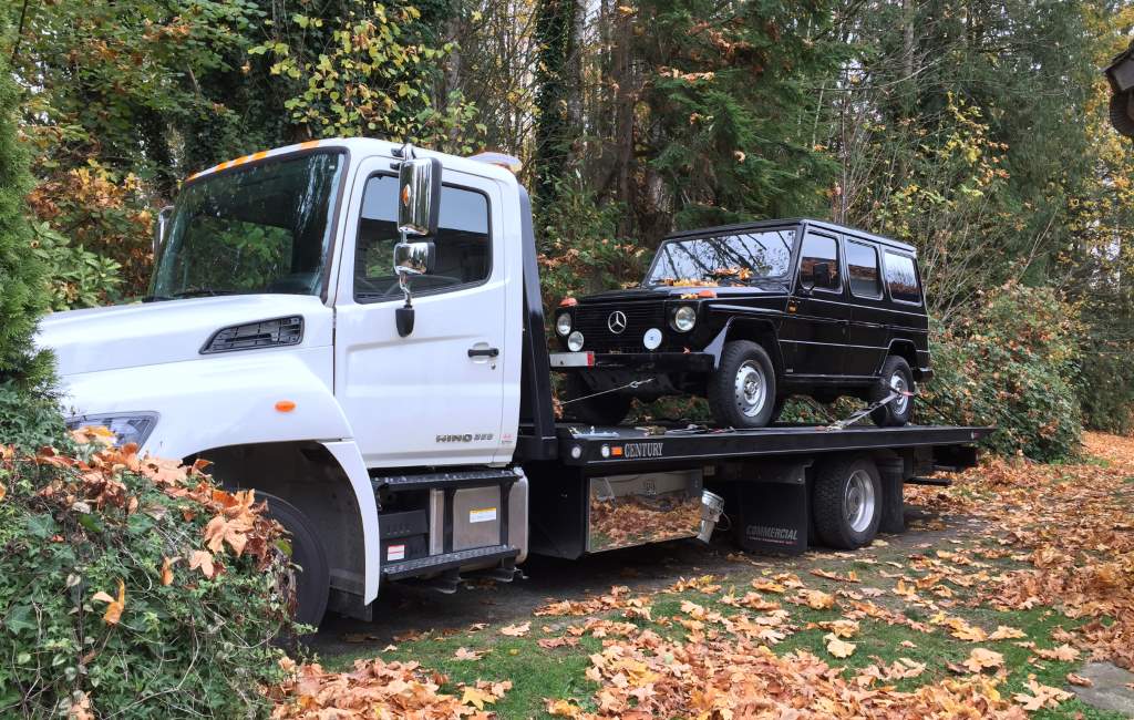 SUV loaded onto a Hino flatbed tow truck
