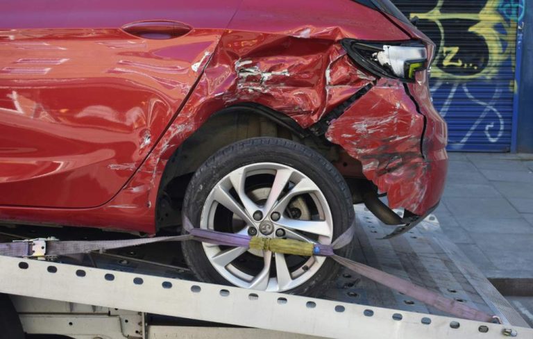 Damaged car strapped onto a flatbed after a collision
