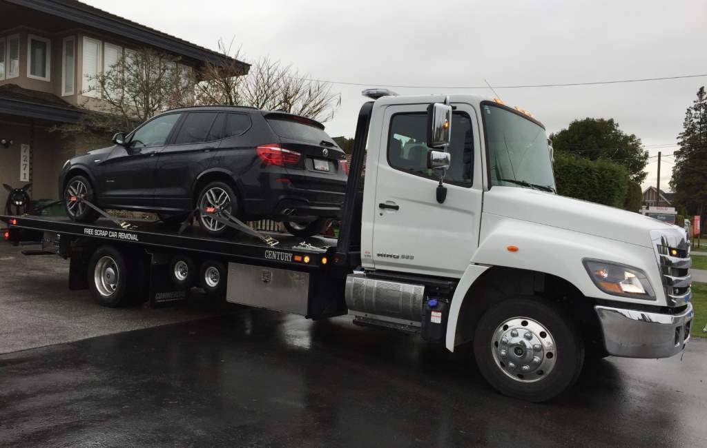 Car being loaded onto a flatbed tow truck